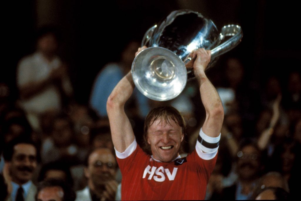 Horst Hrubesch jubelt mit dem Landesmeisterpokal
